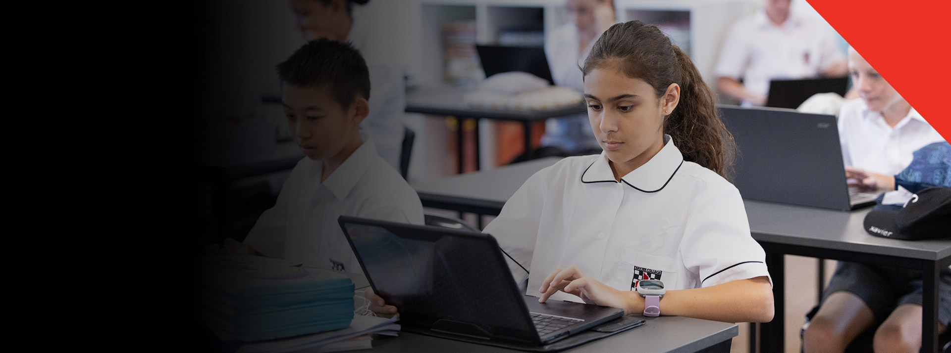 Student working on her laptop in the classroom at Xavier College Llandilo