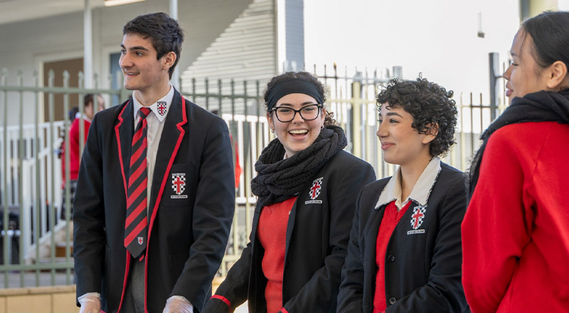 Students laughing together in the school grounds at Xavier College Llandilo