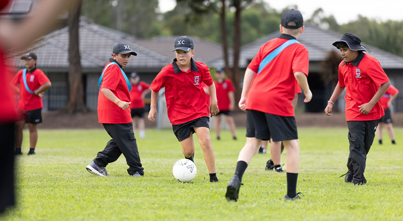 Students playing soccer on the school oval at Xavier College Llandilo