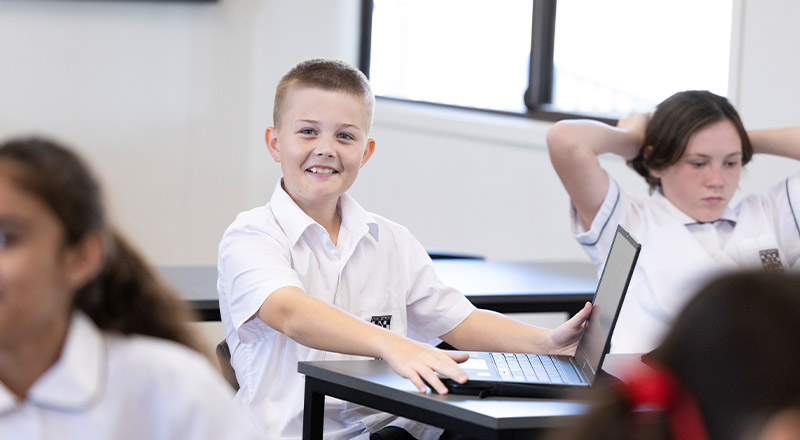 Student smiling in the classroom at Xavier College Llandilo