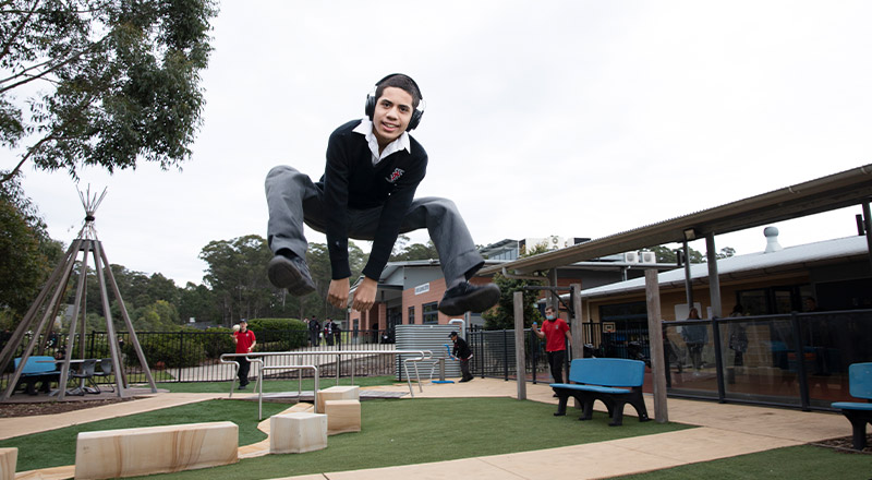 Student jumping on the trampoline in the Kirinari playground at Xavier College Llandilo