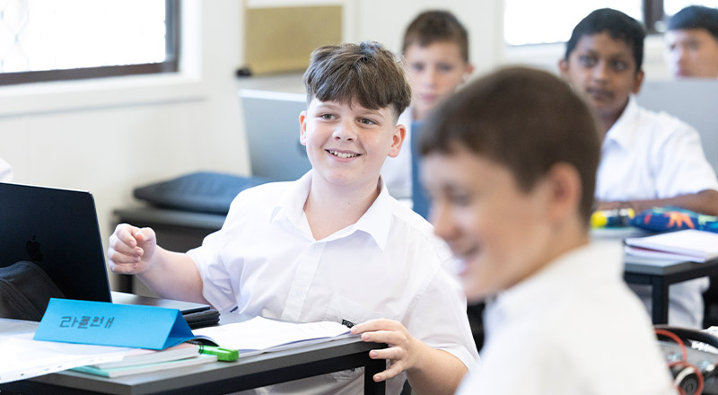 Student smiling in the classroom at Xavier College Llandilo