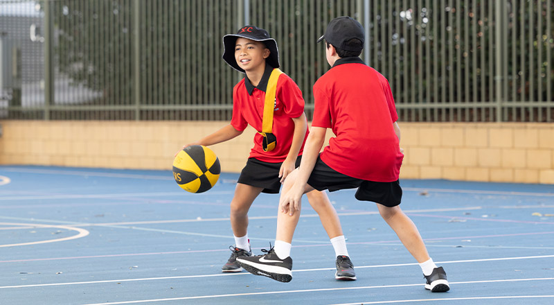 Students playing basketball on the basketball courts at Xavier College Llandilo