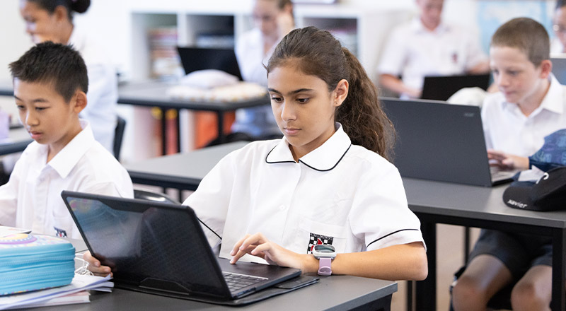 Student working o her laptop in the classroom at Xavier College Llandilo