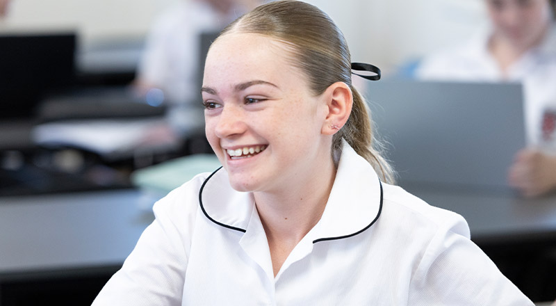 Student smiling in the classroom at Xavier College Llandilo