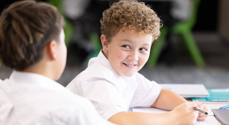 Student smiling in the classroom at Xavier College Llandilo