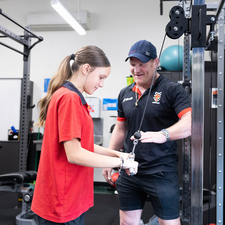 Teacher assisiting a student in the school gym at Xavier College Llandilo