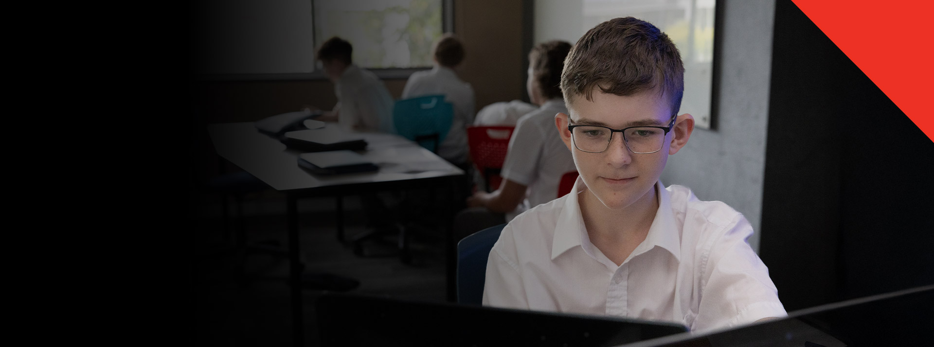 Stuent working on his laptop in the classroom at Xavier College Llandilo