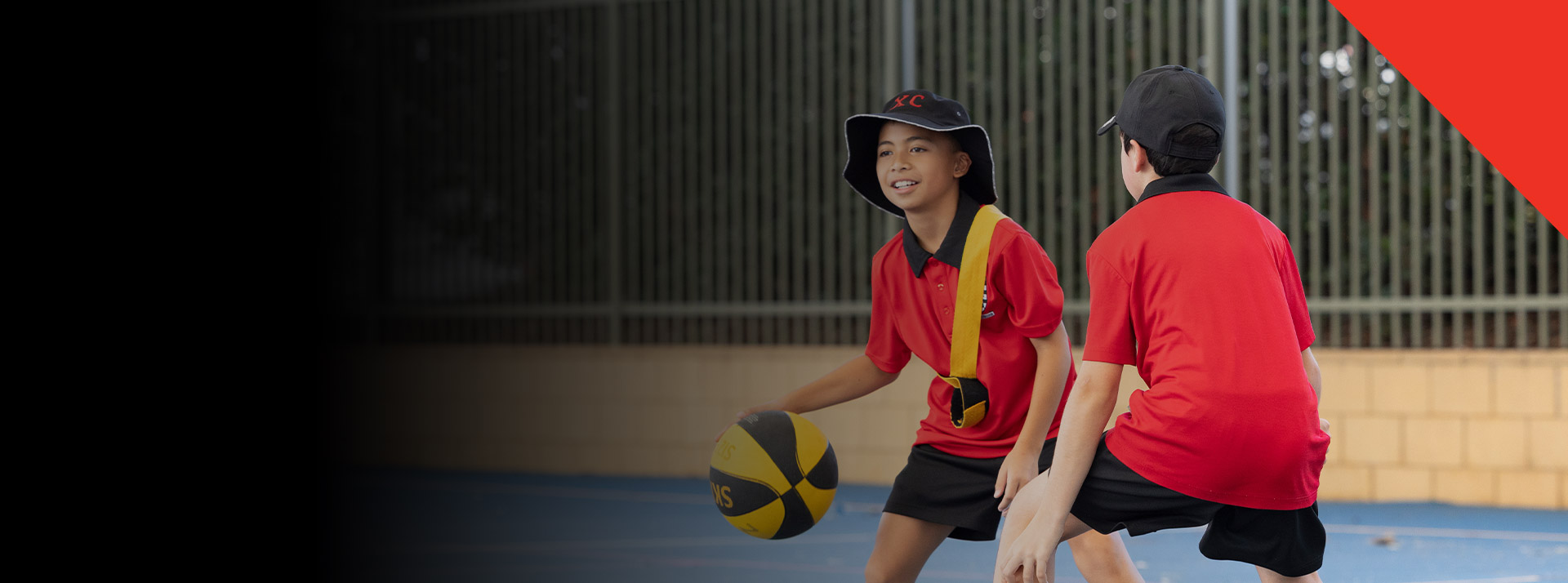 Students playing basketball on the school basketball court at Xavier College Llandilo