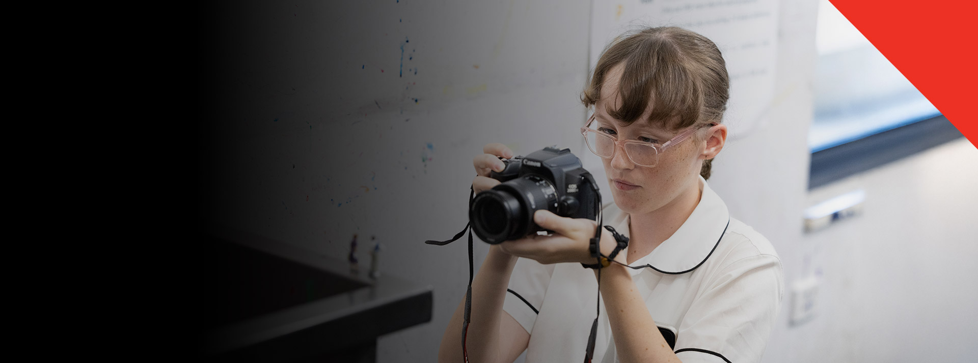 Student taking photos with a camera in the classroom at Xavier College Llandilo