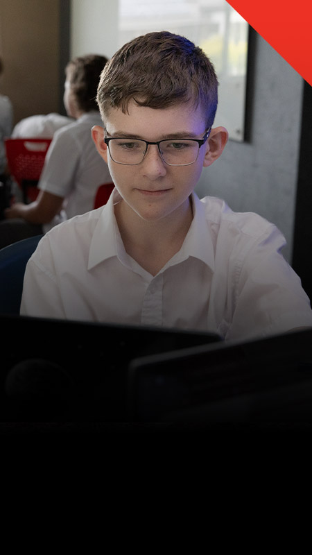 Student working on his laptop in the classroom at Xavier College Llandilo