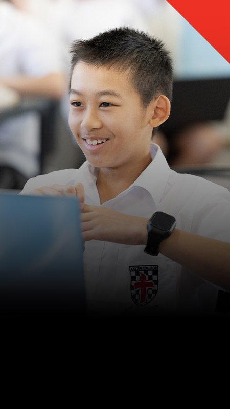 Student smiling in the classroom at Xavier College Llandilo