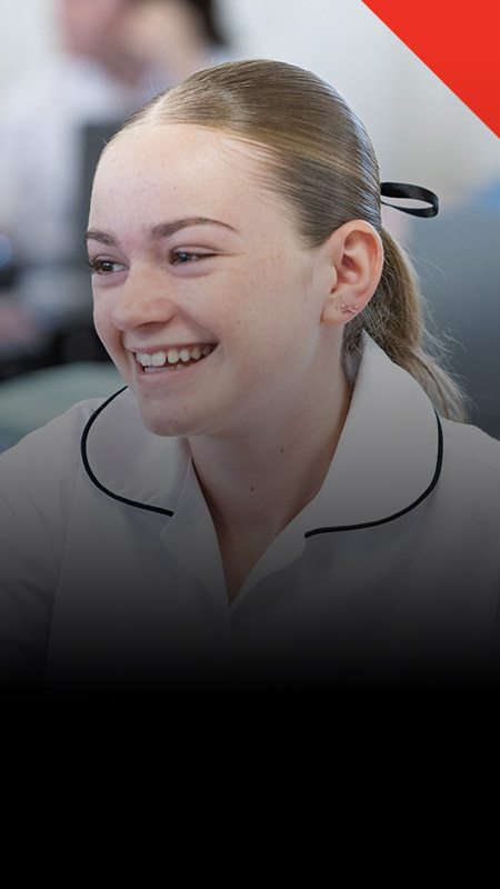 Student smiling in the classroom at Xavier College Llandilo
