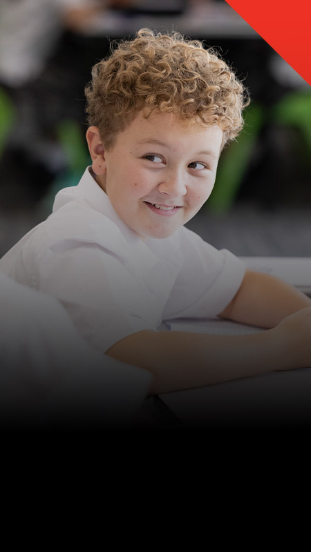 Student smiling in the classroom at Xavier College Llandilo